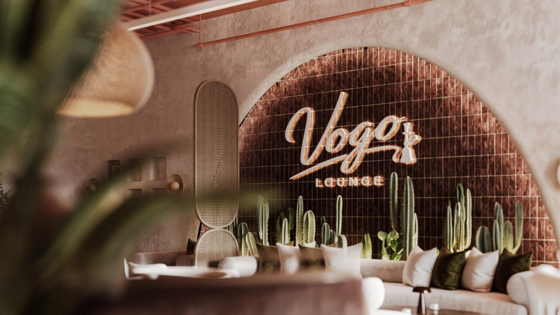 The Vogo sign glowing through the plants